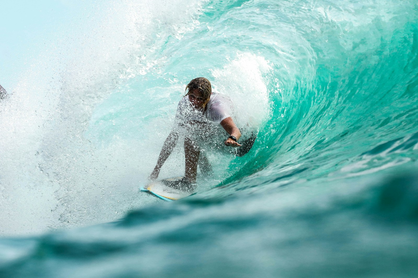 Surfer riding inside the barrel of a turquoise wave — boards sourcing for NZ and AU buyers