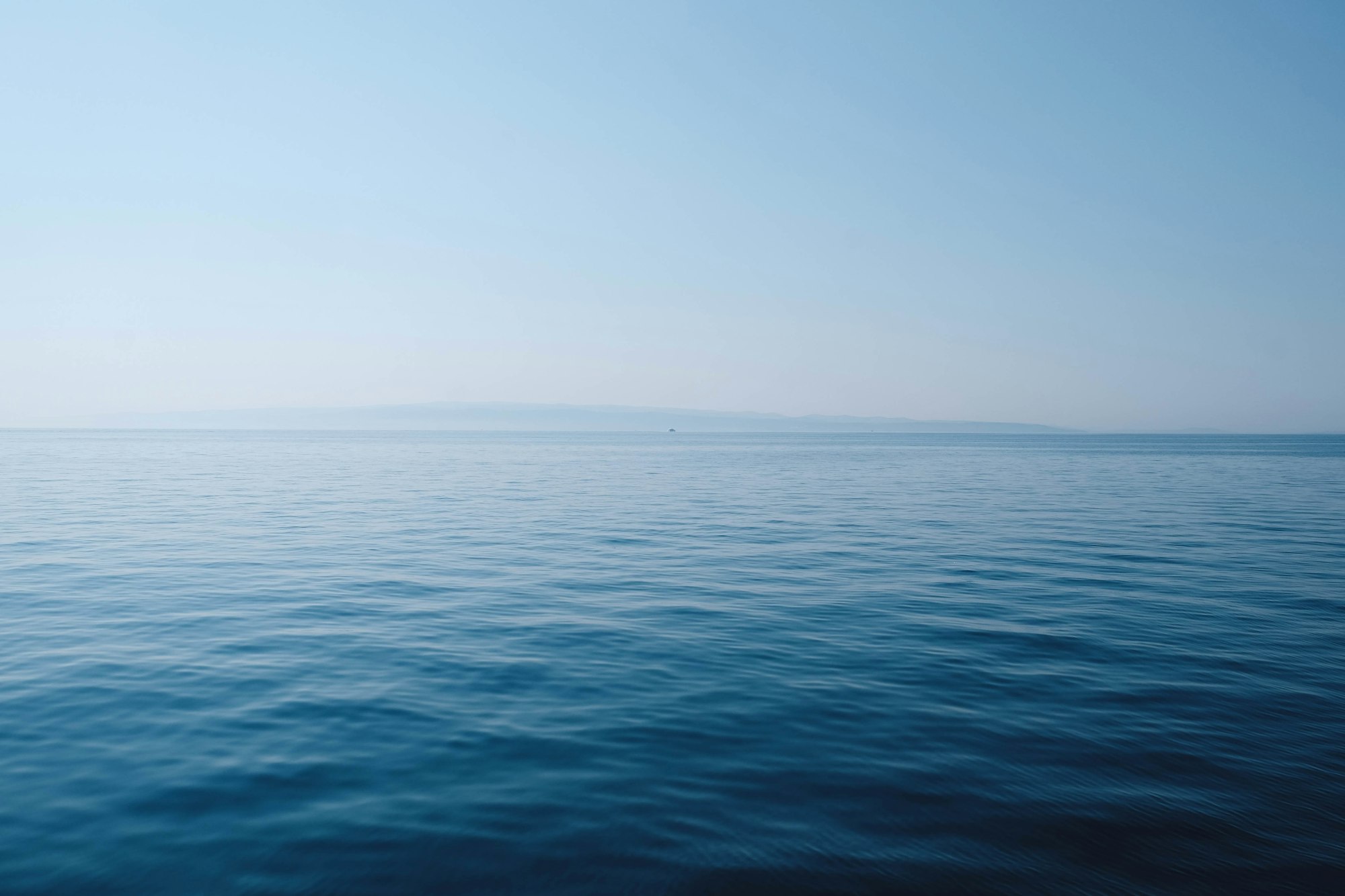 Calm open ocean stretching to the horizon under a clear sky